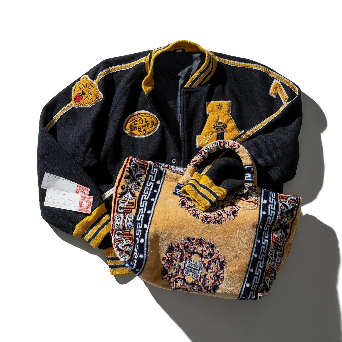 Navy tote bag with yellow trim, embroidered patches, and looped top handles