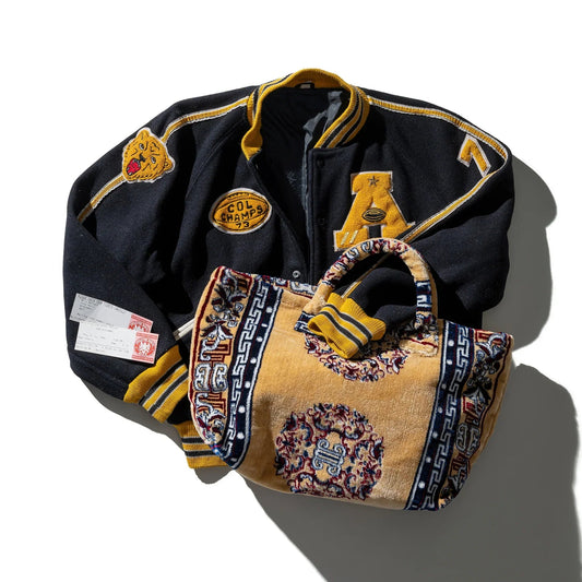 Navy tote bag with yellow trim, embroidered patches, and looped top handles