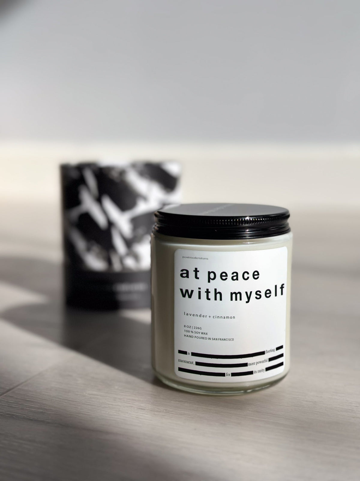 Lavender and cinnamon scented jar candle with black lid and white label.