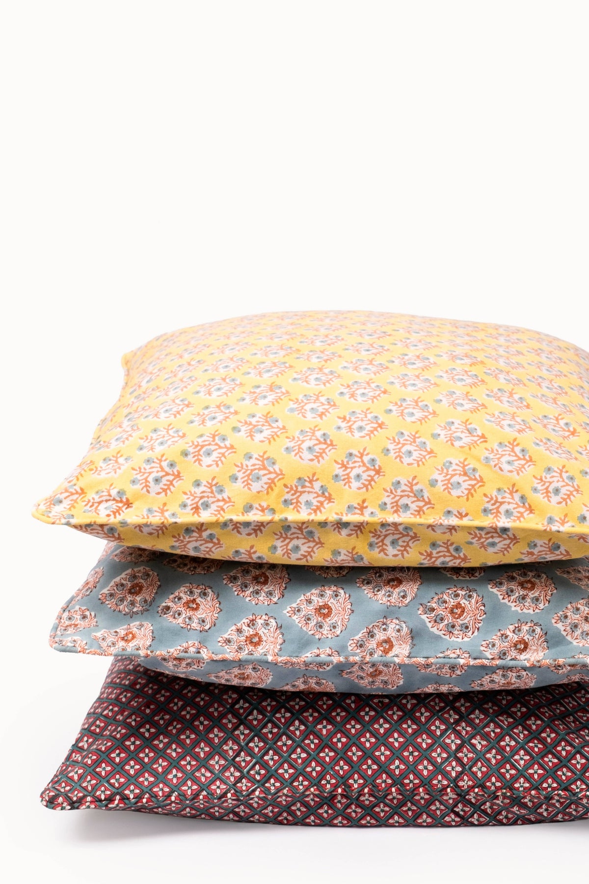 Stacked square pillow covers featuring crimson diamond pattern with dark piping
