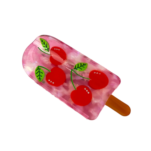 Cherry popsicle hair claw with translucent pink base, red cherry print, and tan prongs