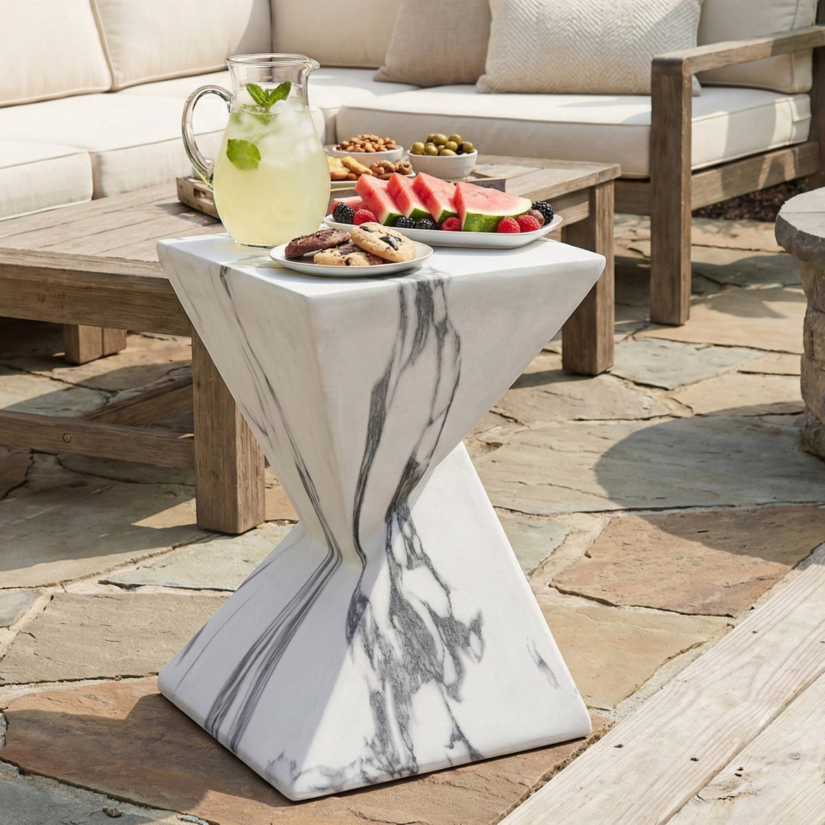 Sculptural concrete side table with white and gray marble-like veining, shown outdoors
