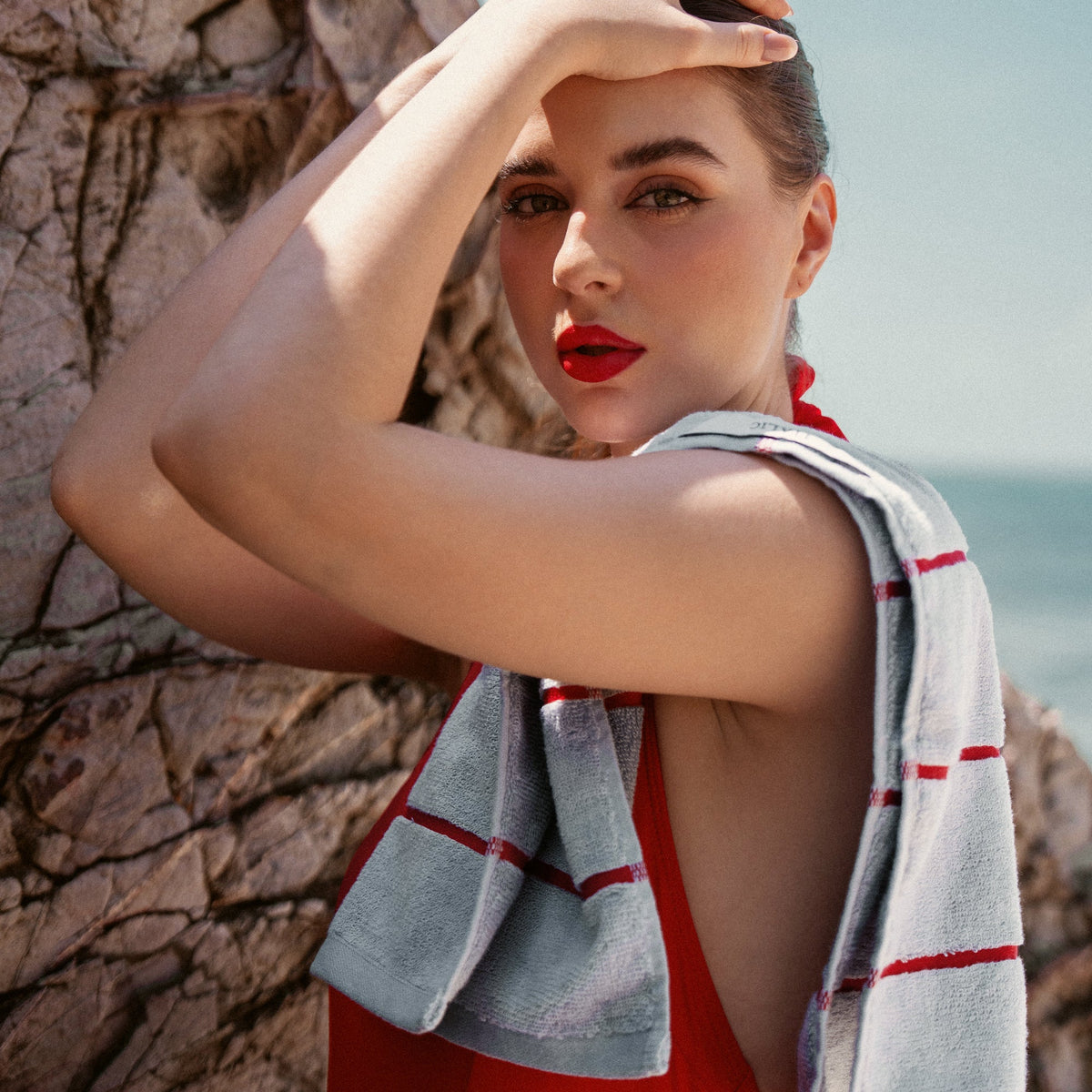 Light gray cotton towel with red stripe pattern draped over shoulder