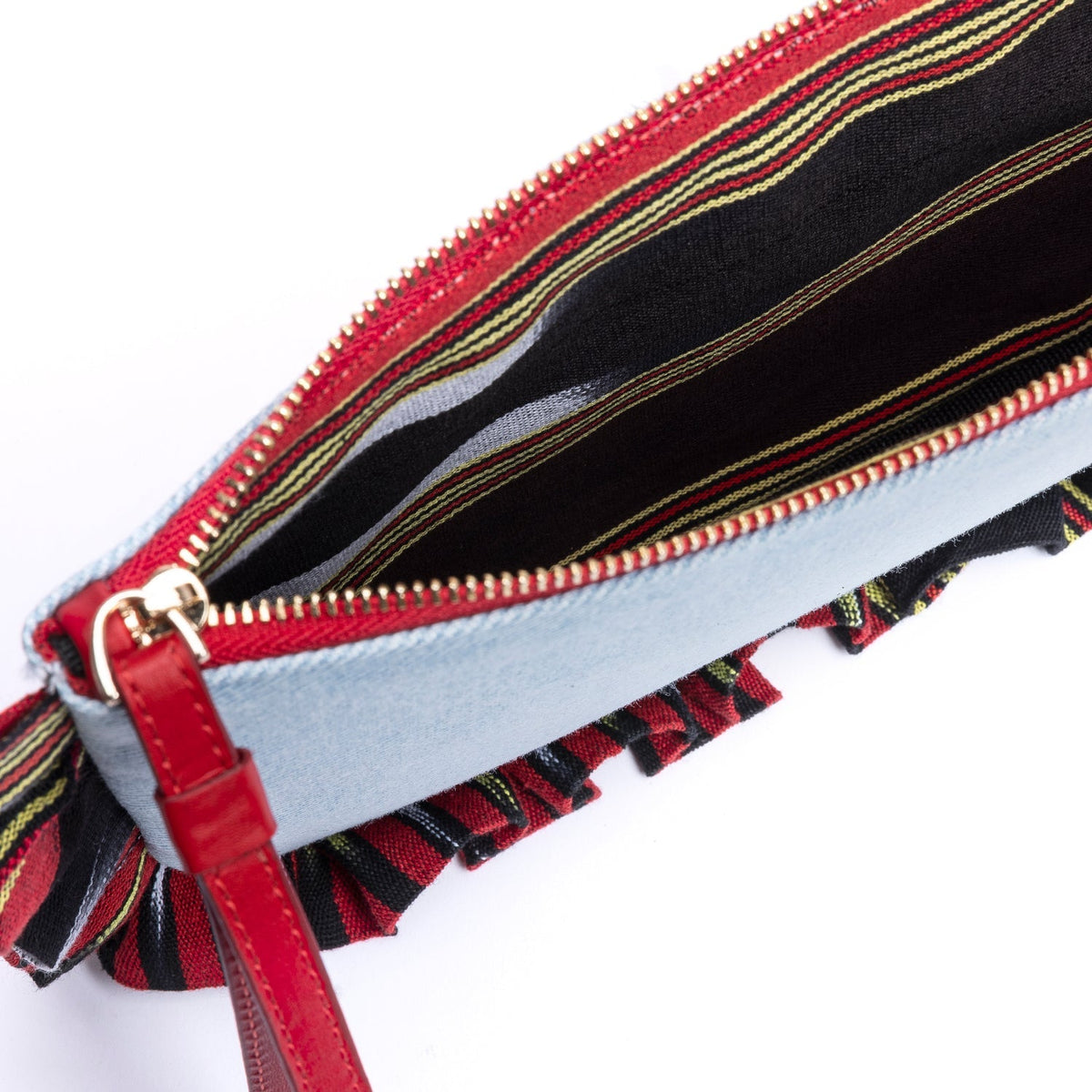 Denim clutch close-up showing red zipper pull and colorful striped fringed lining