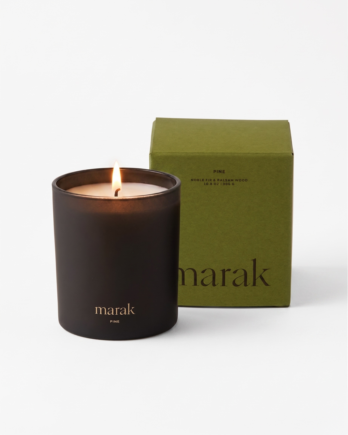 Black marak candle jar with flame next to green marak candle box