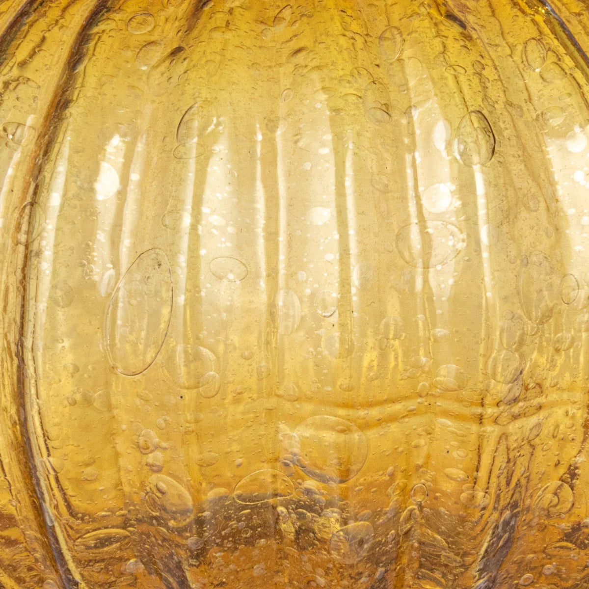 Amber hand-blown glass vase close-up with bubbled texture and rippled glass