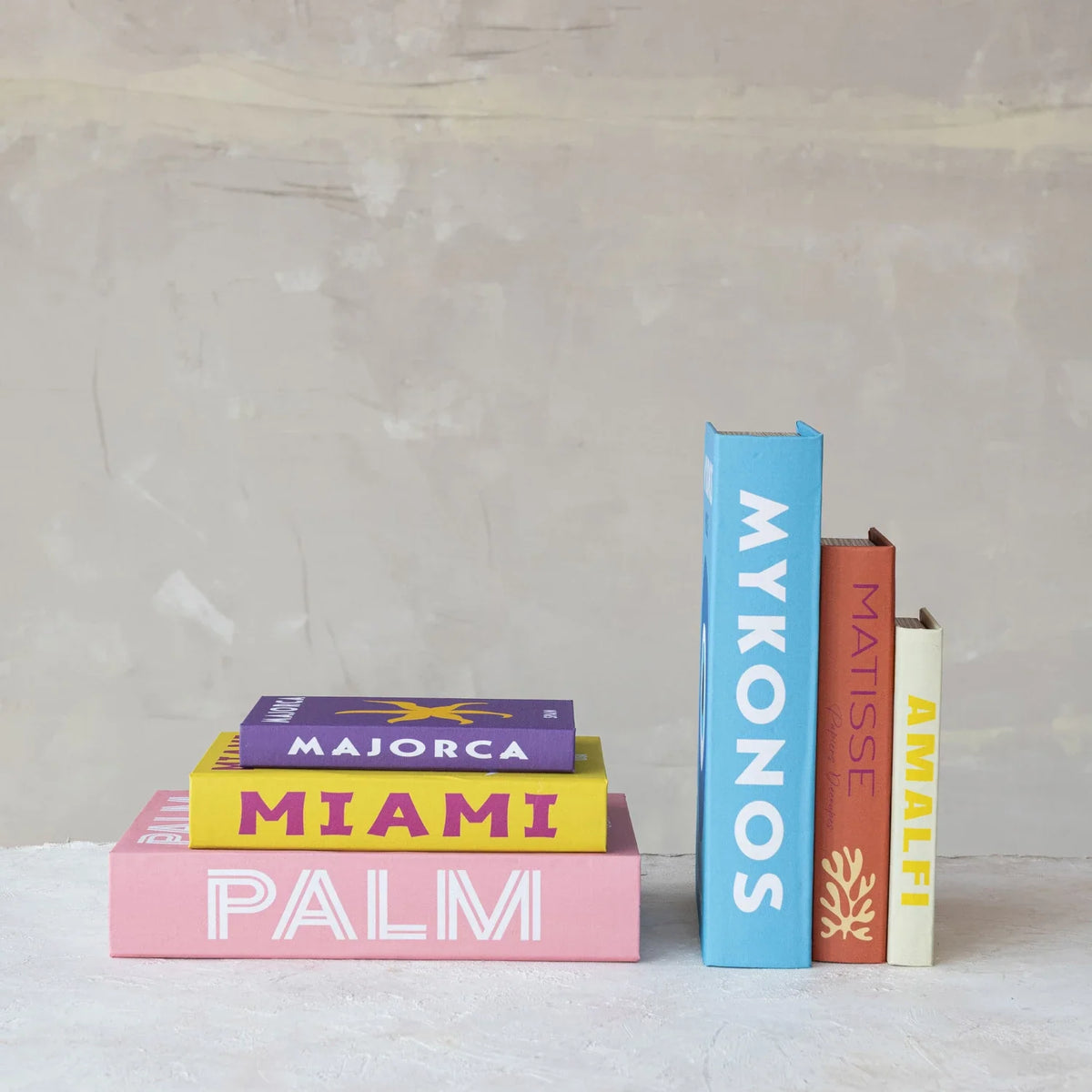 Canvas book storage boxes standing with blue, tan, and cream tropical spines