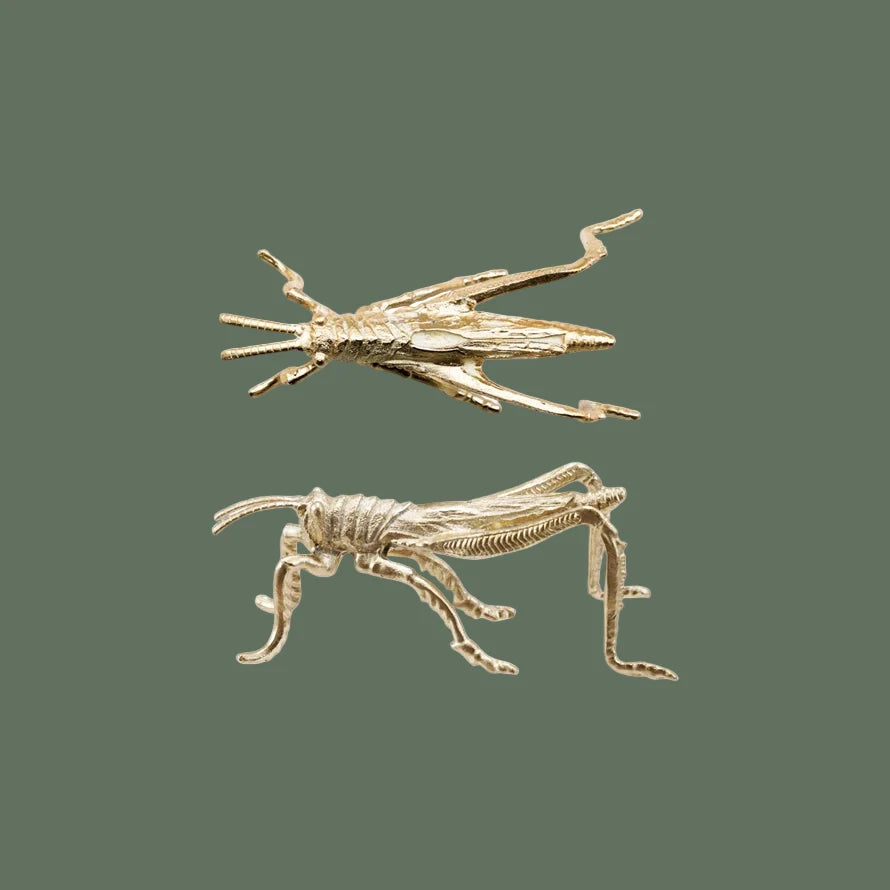 Pewter grasshopper ornament with gold finish, two angled figures
