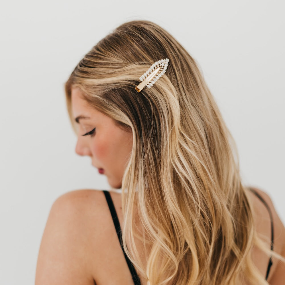 Pearl-and-diamond hair barrette clip with white stones on blonde hair