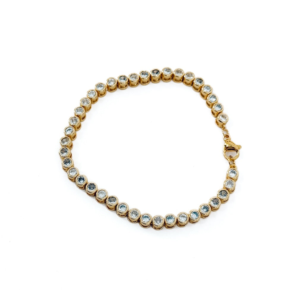 Gold tennis bracelet with round clear stones and a clasp