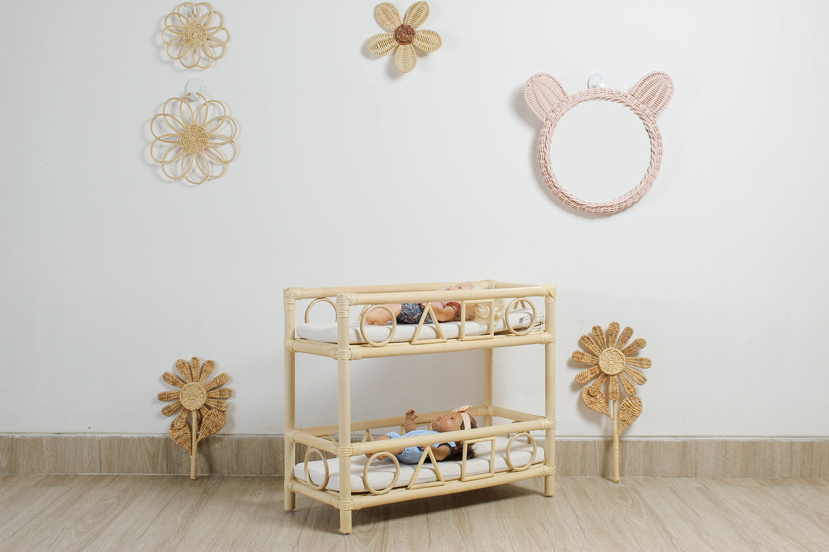 Pink rattan teddy bear wall mirror above a woven shelf with dolls
