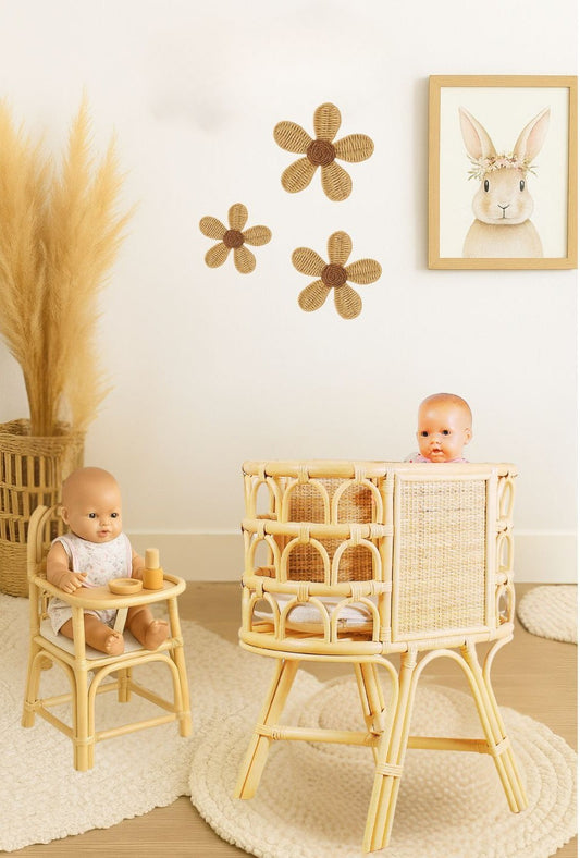 Natural rattan doll crib with raised legs, woven panels, and open arched sides
