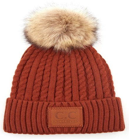 Rust ribbed knit beanie with faux fur pom-pom and front logo patch
