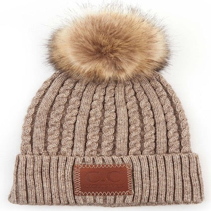 Beige ribbed knit beanie with faux fur pom-pom and front logo patch