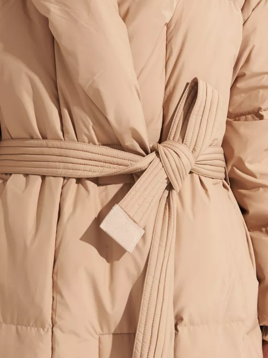 Close-up of the coat's stitched belt knot and quilted fabric