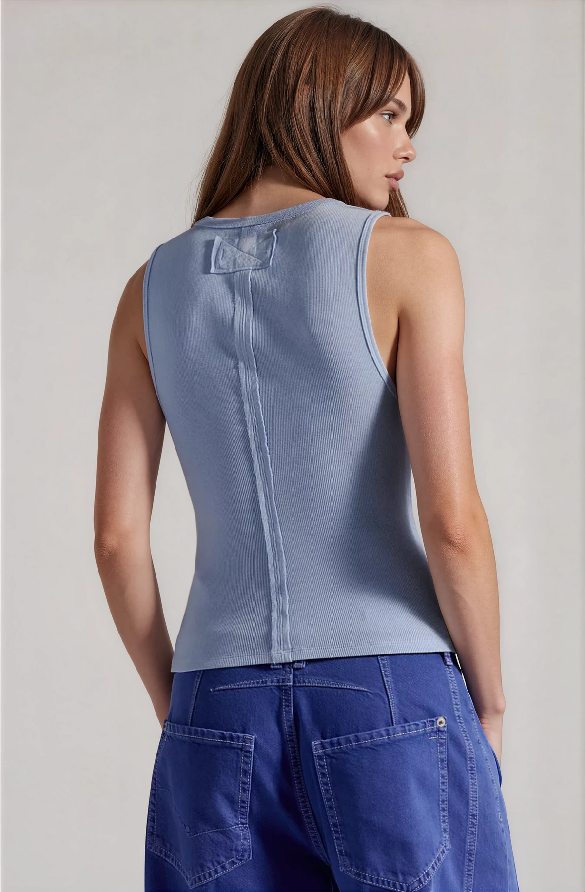 Back view of blue henley tank top with yoke seams and sleeveless fit