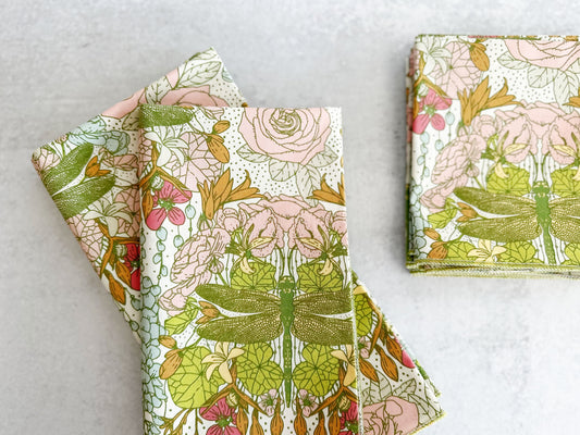 Floral dragonfly cloth napkins, folded, pink and green leaf pattern, set of four