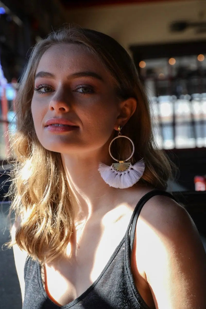 Gold hoop earrings with white fan tassels