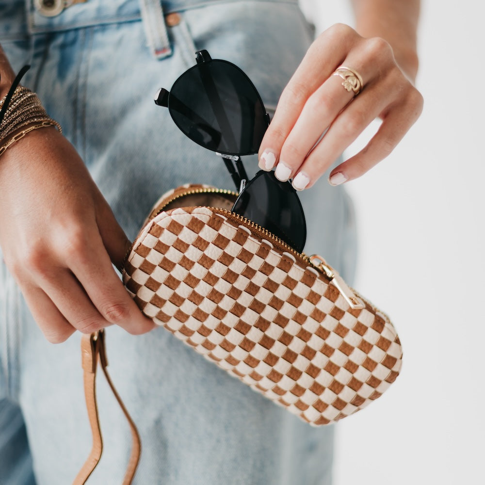 Woven checkered sunglass case wristlet with tan strap and gold zipper trim