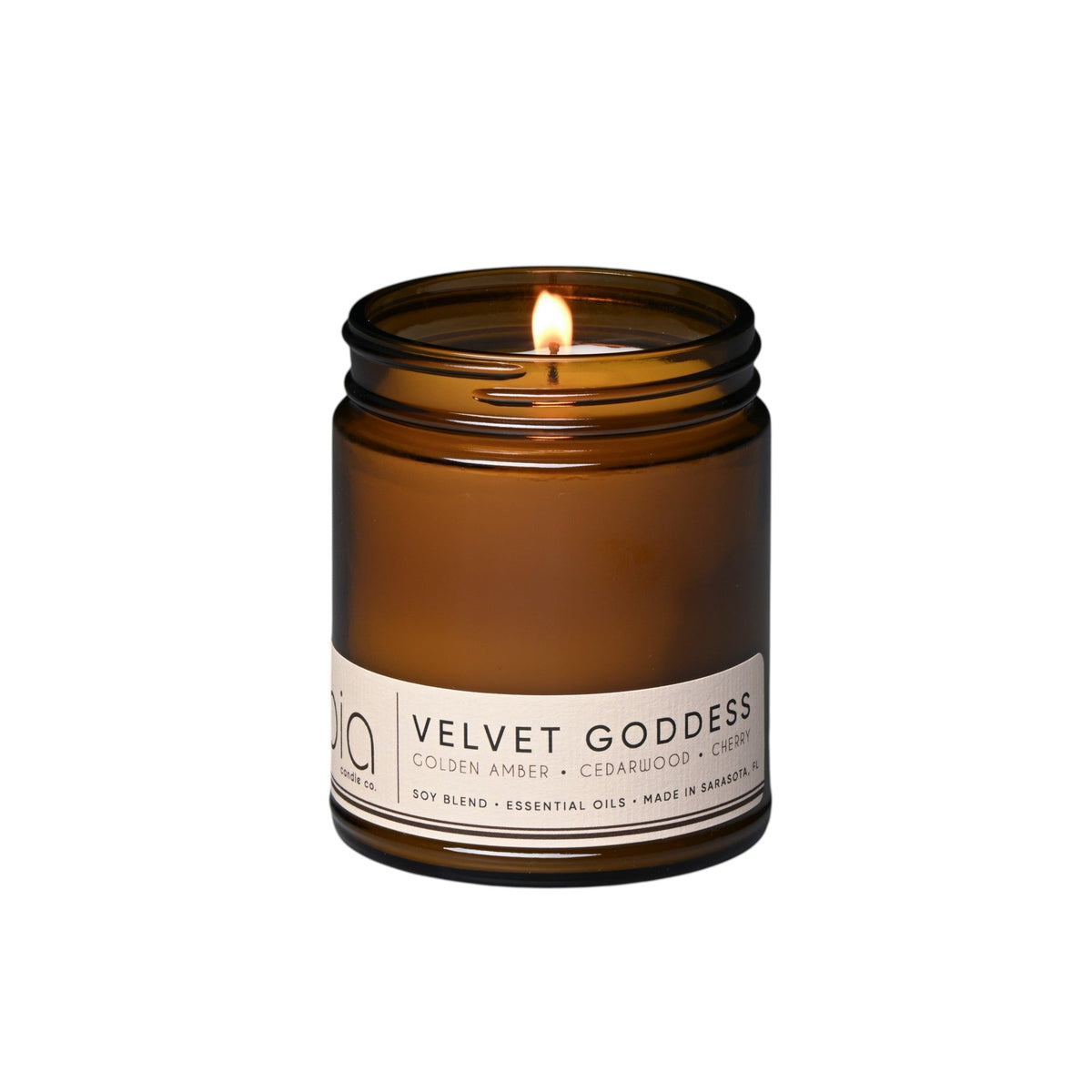 Amber glass soy candle jar with one lit wick and front label