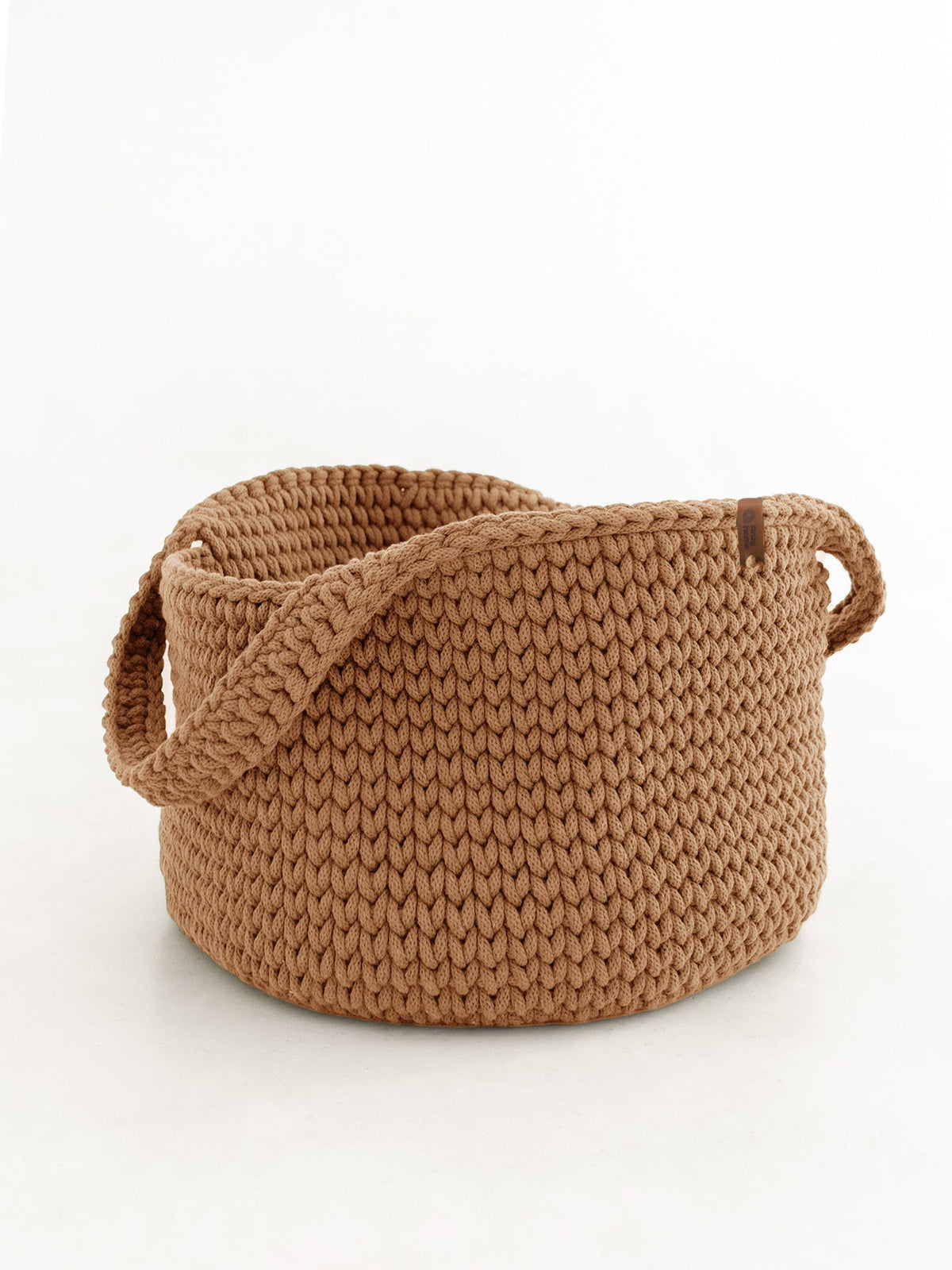 Round knitted storage basket with handles in tan beige, woven knit texture
