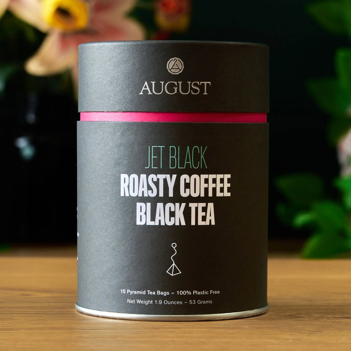 Jet Black Roasty Coffee Black Tea in a black cylindrical tin with a pink band.