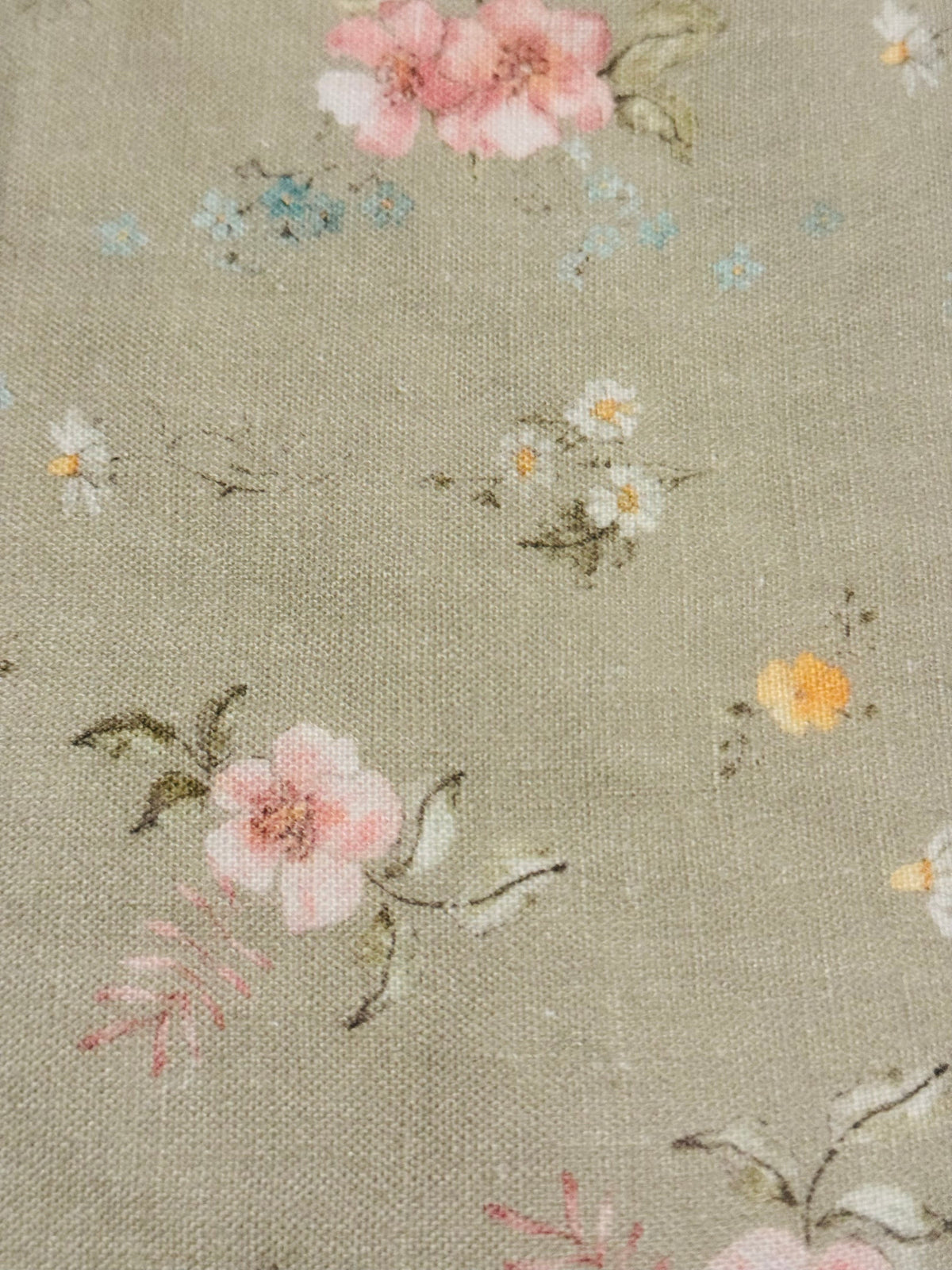 Infant bib fabric close-up with sage base and multicolor hedgerow floral sprigs