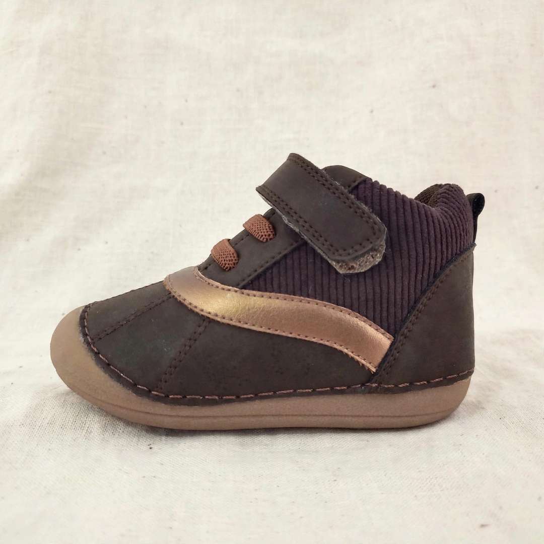 Kids barefoot boot side close-up, dark brown suede, tan band, elastic cuff, strap