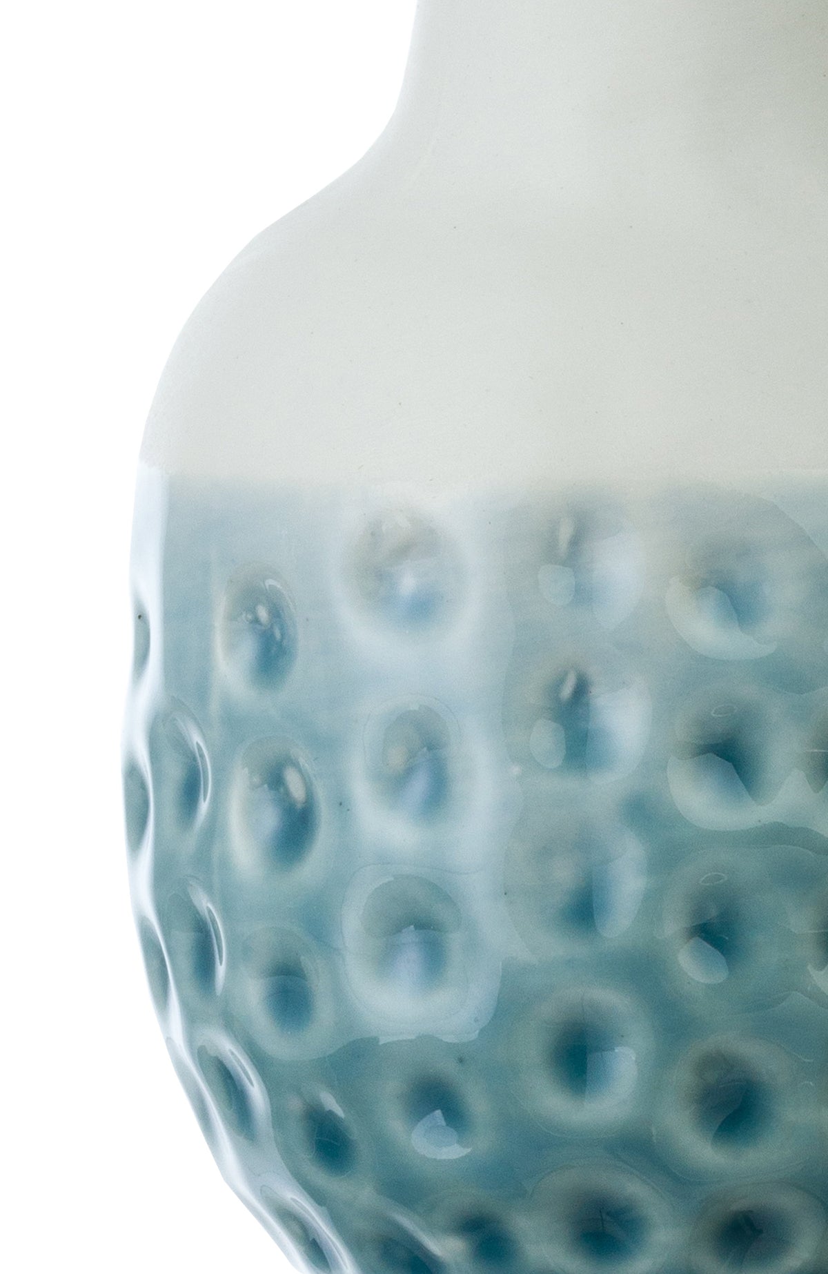 Close-up of light blue ceramic vase with embossed dot pattern texture