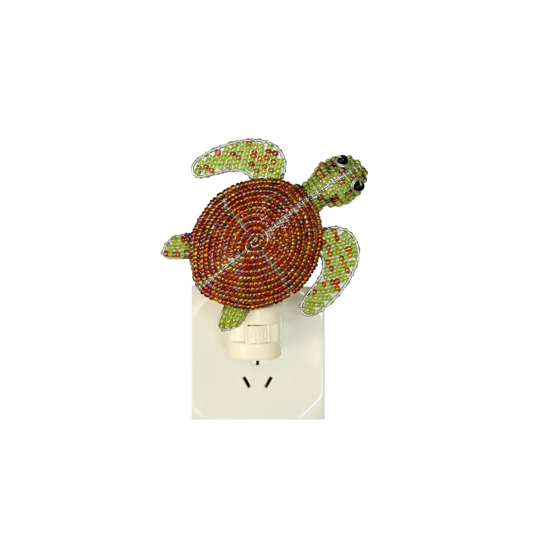 Sea turtle night light with green-and-orange bead details on white plug-in base