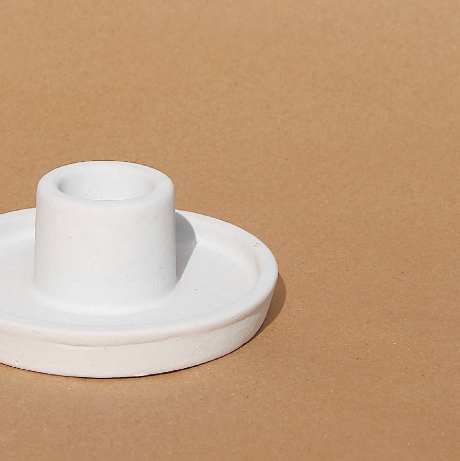 White ceramic candle holder close-up, round base with raised center cup