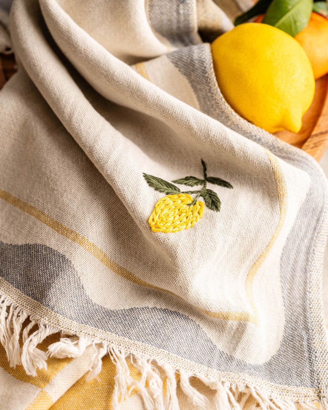 Kitchen towel with small lemon embroidery and yellow check border; fringed edge corner