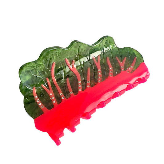 Green and red translucent hair claw with pink base and raised comb teeth