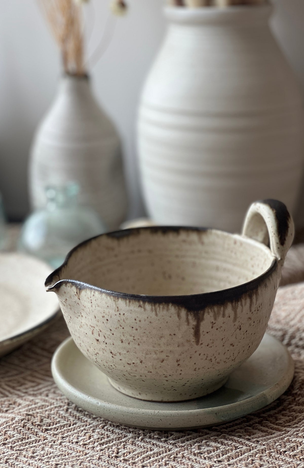 Speckled cream batter bowl with dark rim and loop side handle
