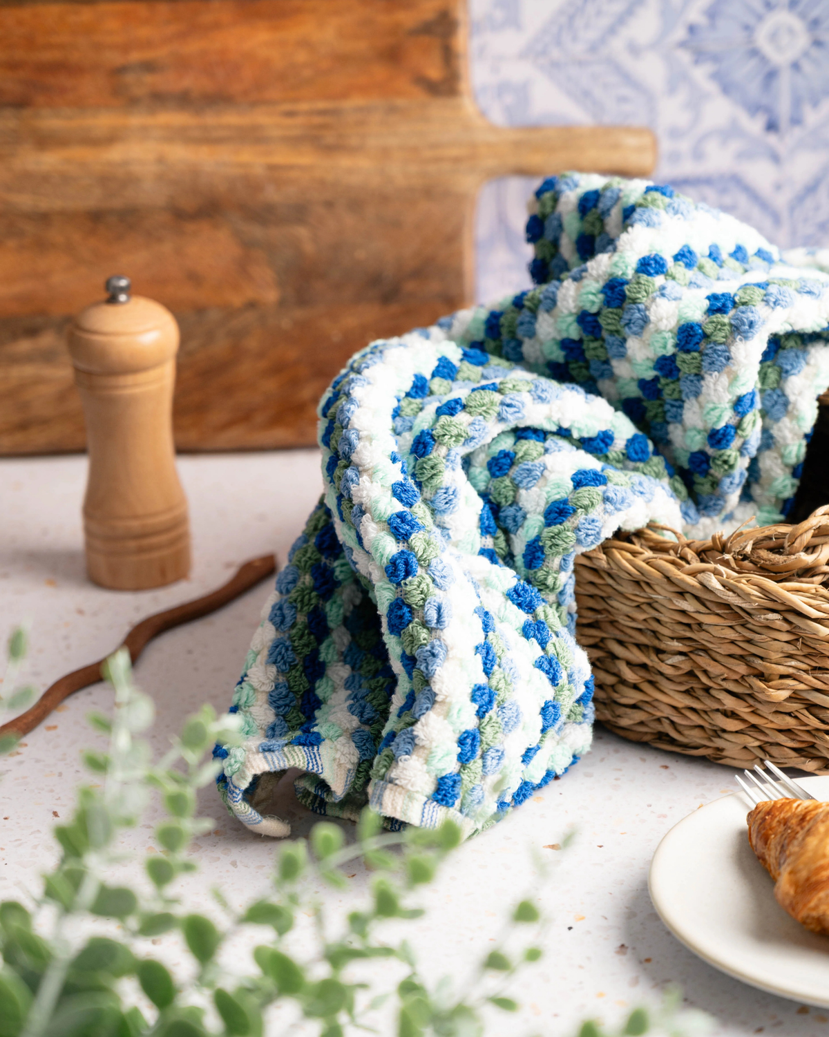 Checkered hand towel in blue and mint tones, no tassels, folded on a surface.