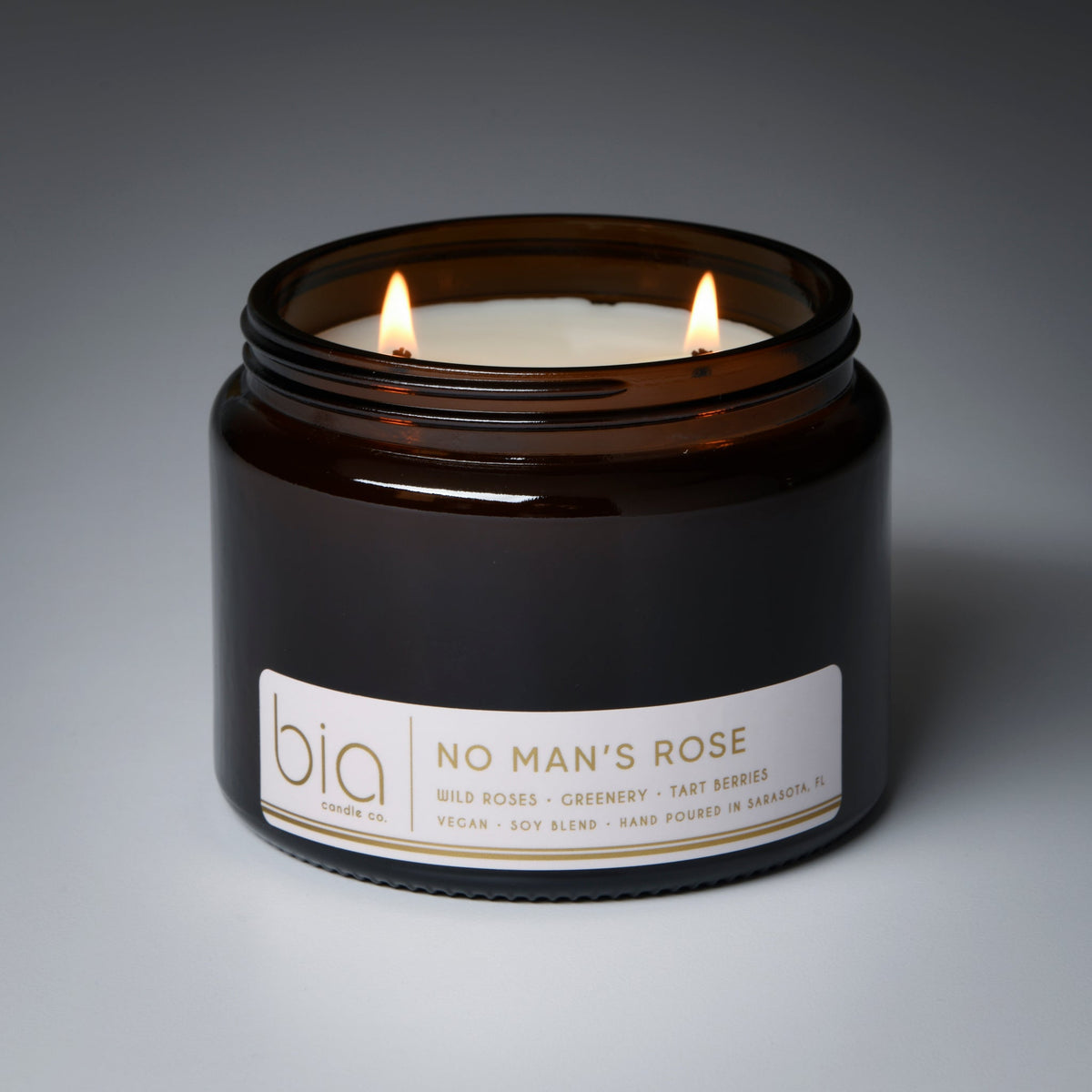 Brown soy blend candle jar with two flames and white front label