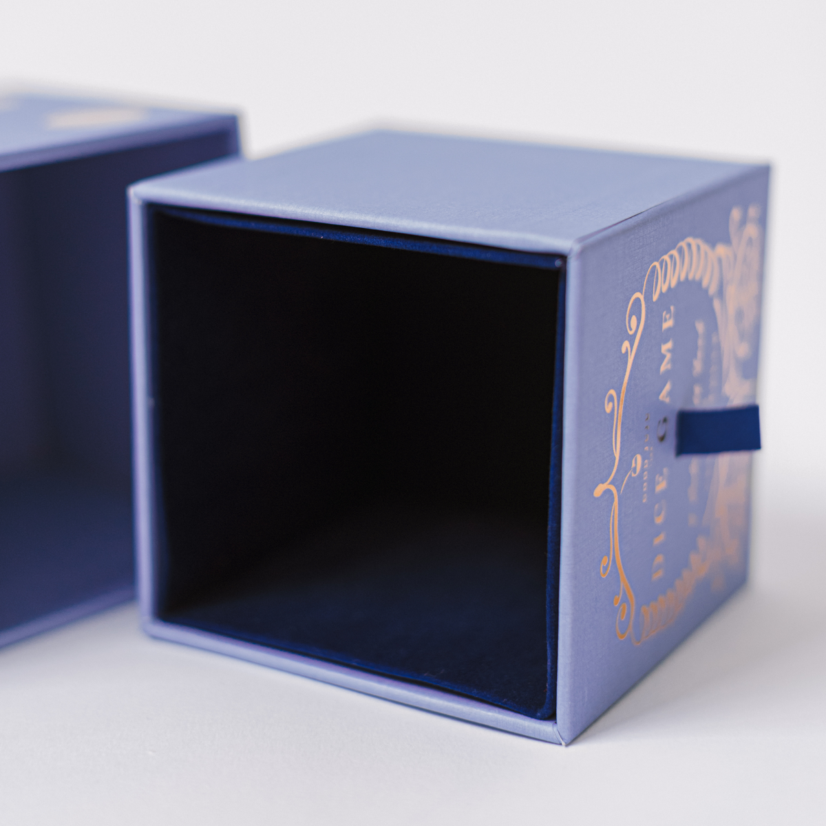 Blue storage box with open interior and decorative dice-game label on side.