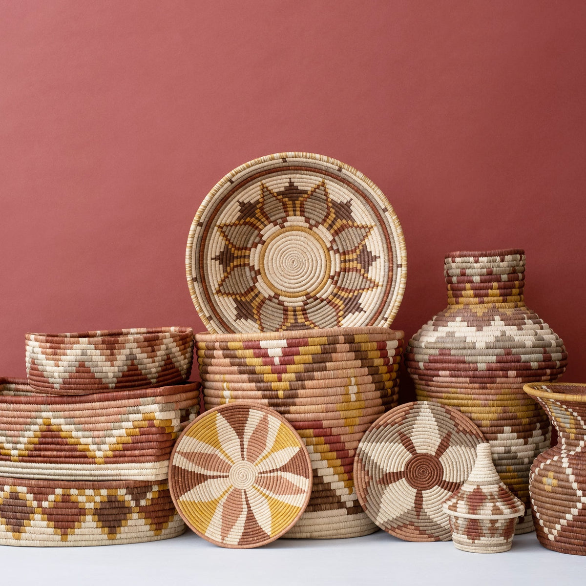Woven coffee basket set on display, includes lidded jars and sunburst coasters in warm tones