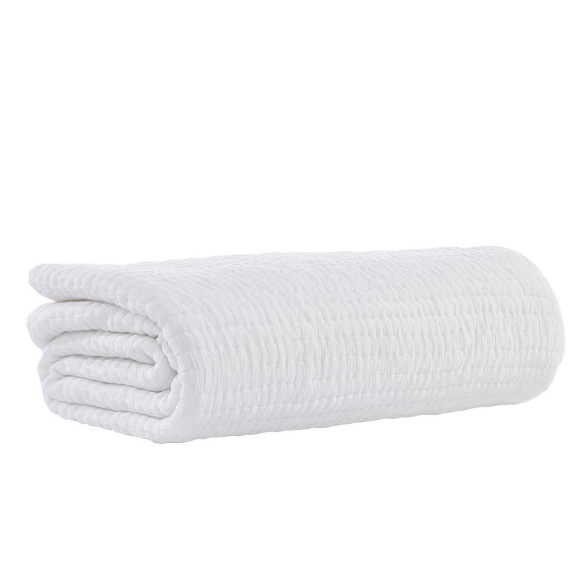 White cotton quilt folded into a roll, crinkled quilted texture visible