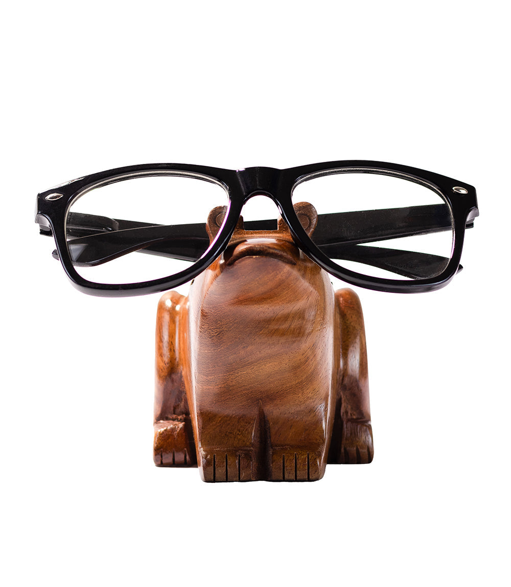 Hand-carved wooden frog eyeglass holder stand holding black eyeglasses