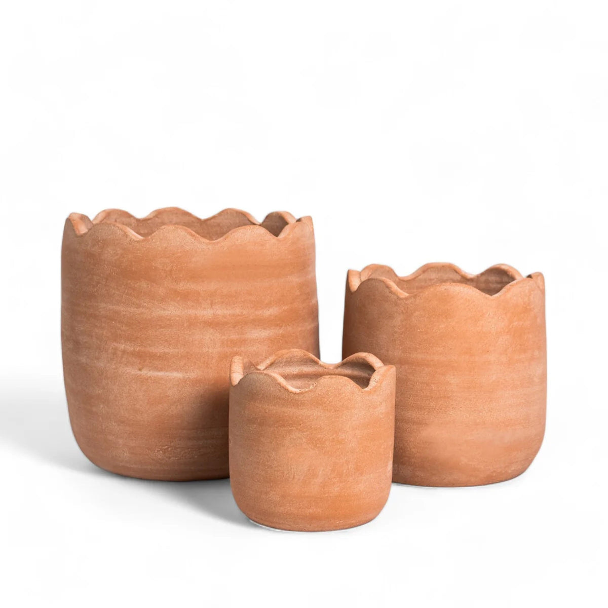 Wavy terracotta planters in three sizes, each with a scalloped top rim