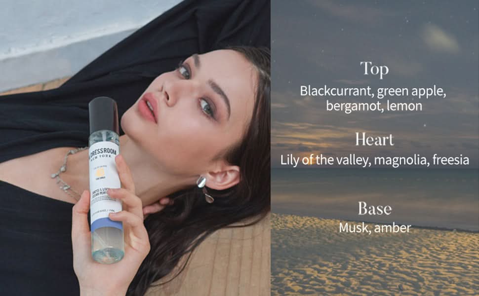 Clear fragrance spray bottle with black pump cap held in hand.
