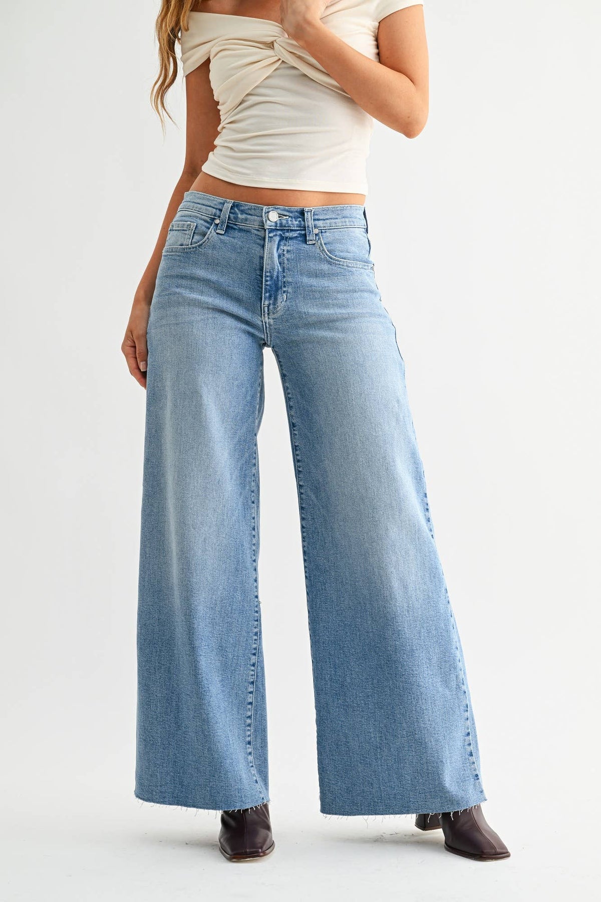 Light wash stretch wide-leg jeans with five-pocket styling and button-zip front