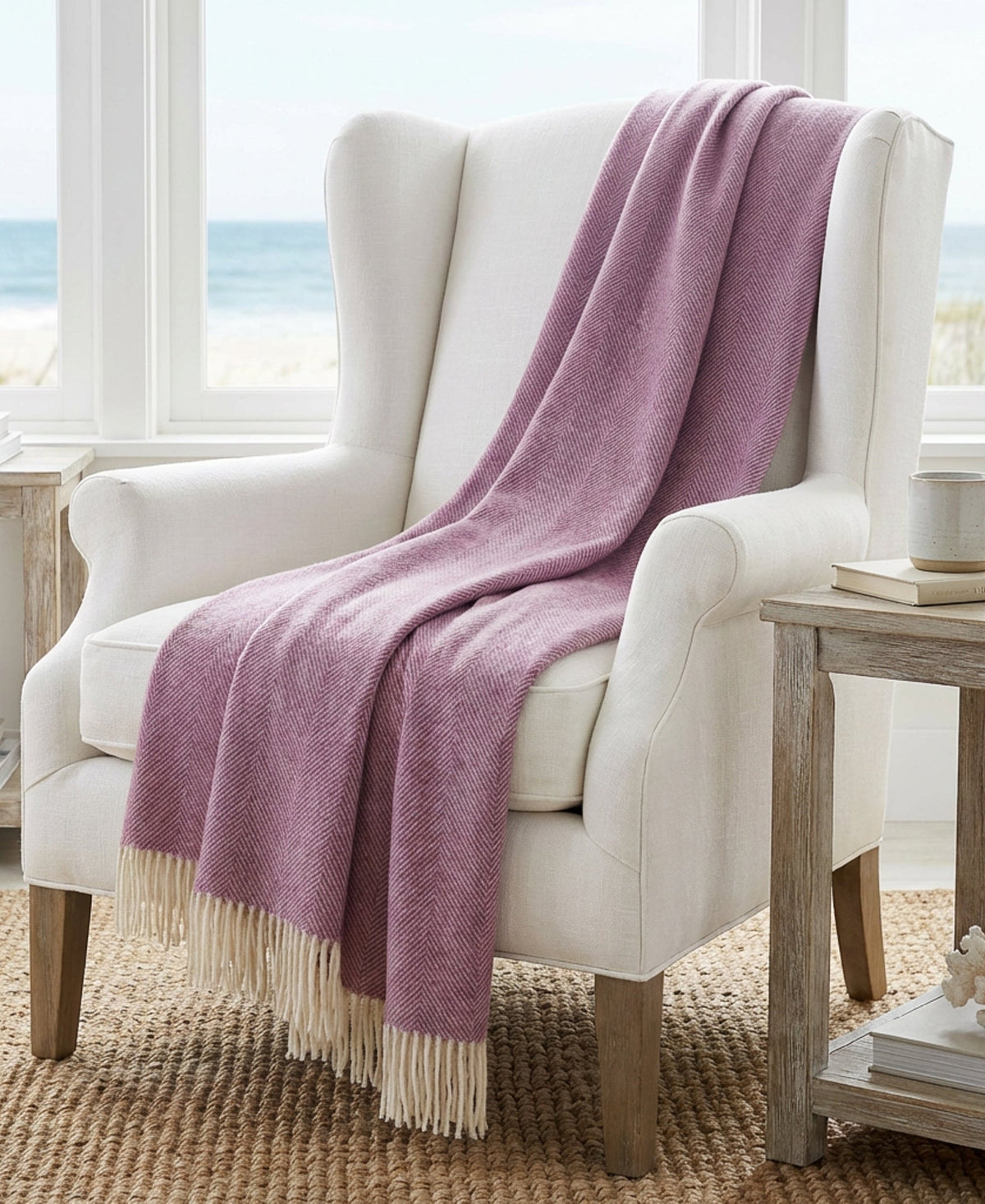 Petal pink herringbone throw blanket draped over an upholstered chair