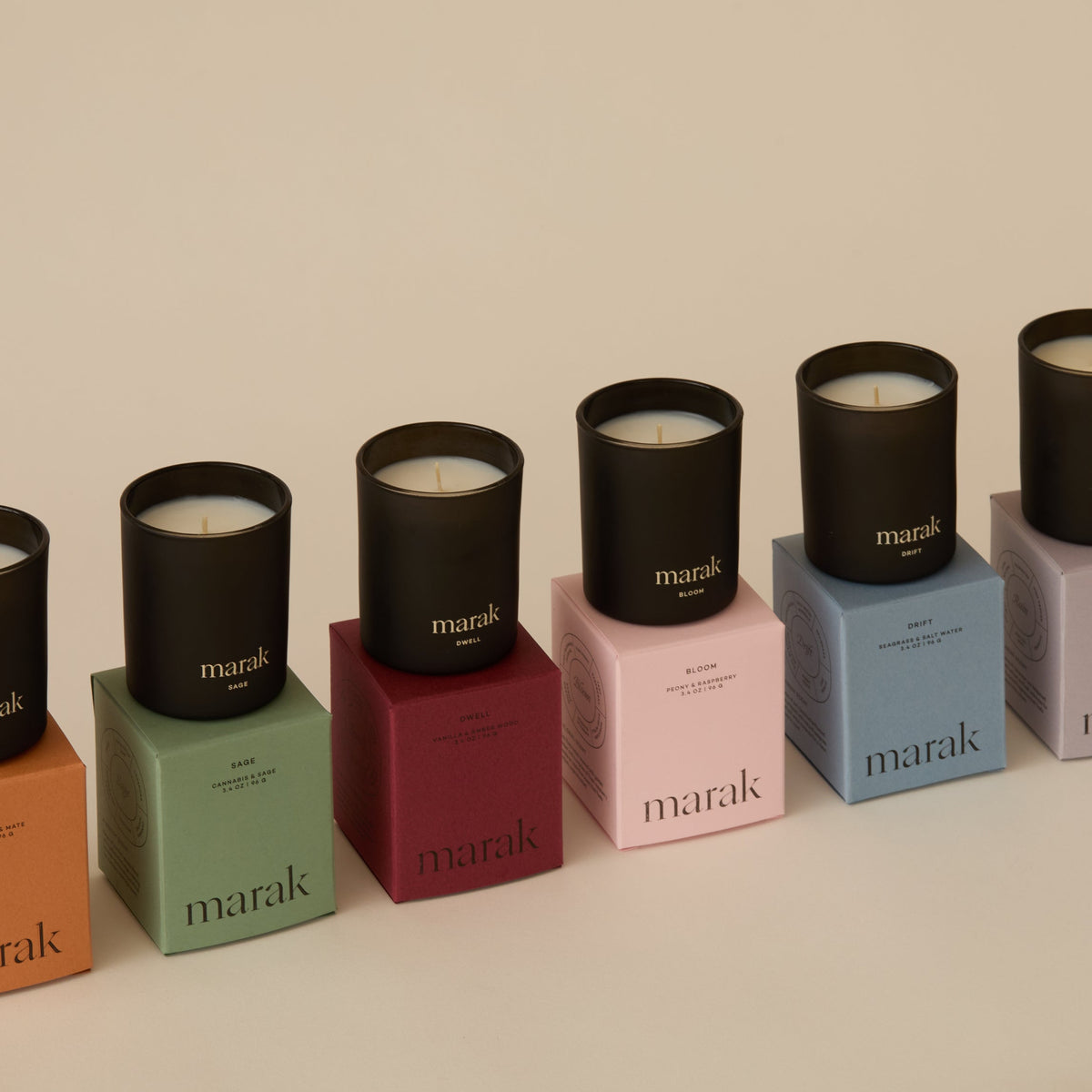 Assorted votive candles: black lids on green, red, pink, and blue cube boxes