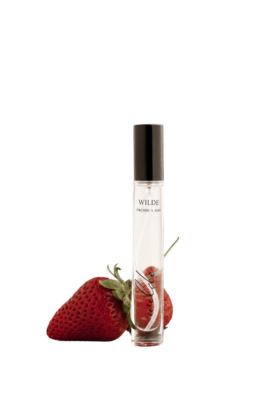 Strawberry travel perfume spray bottle with clear glass body and black cap