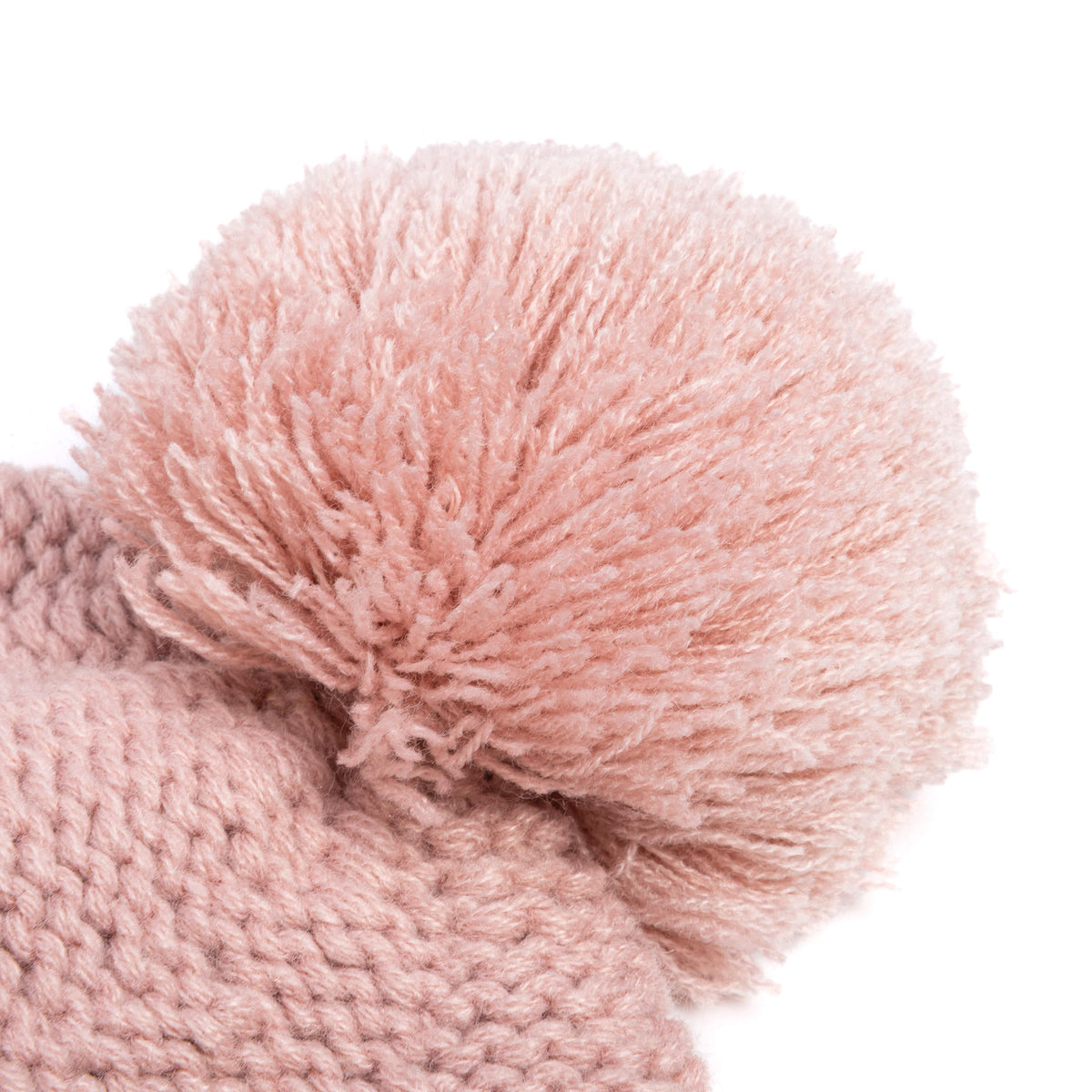 Close-up of fluffy dusty pink pompom on knit beanie