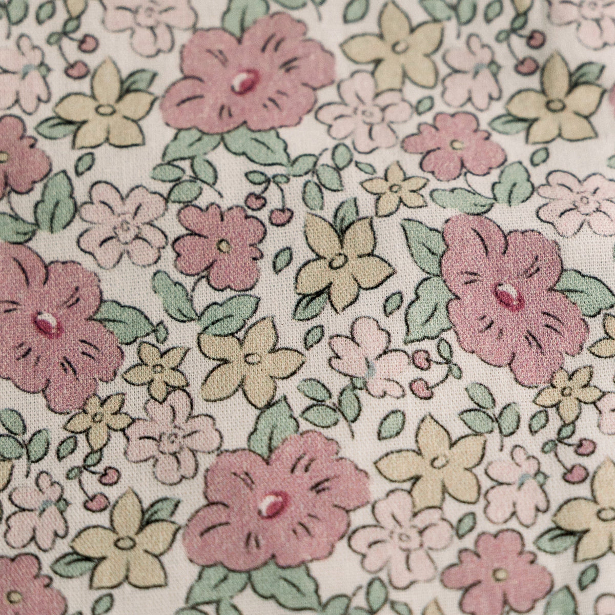 Close-up floral print fabric: pink blossoms, green leaves, and light cream background.