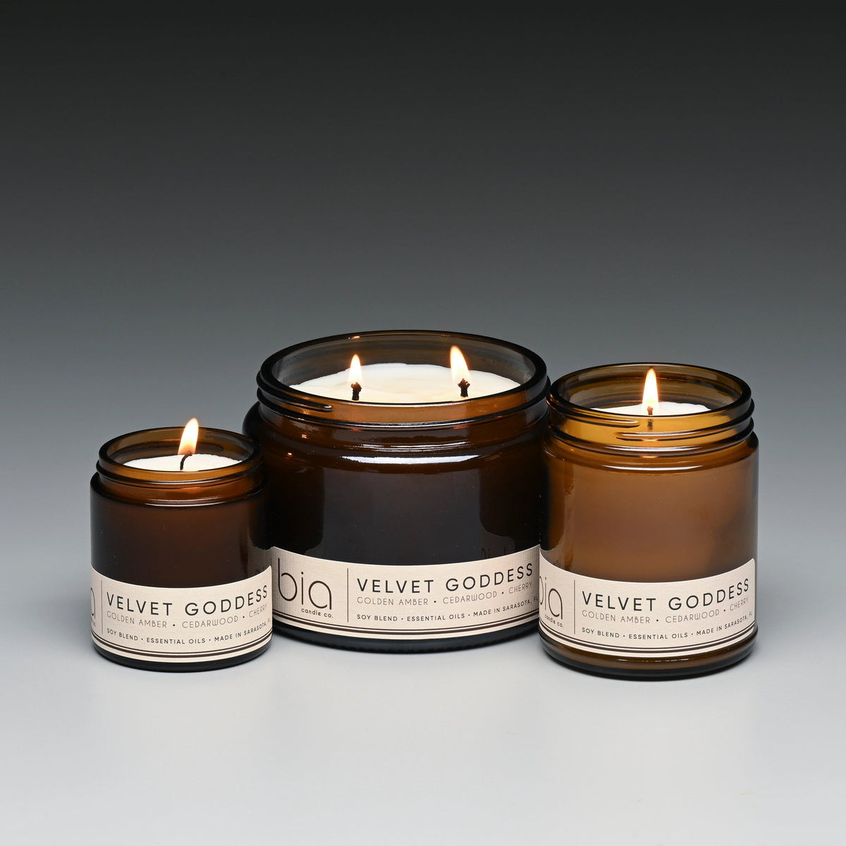 Amber soy blend candle set in brown glass jars with three lit wicks