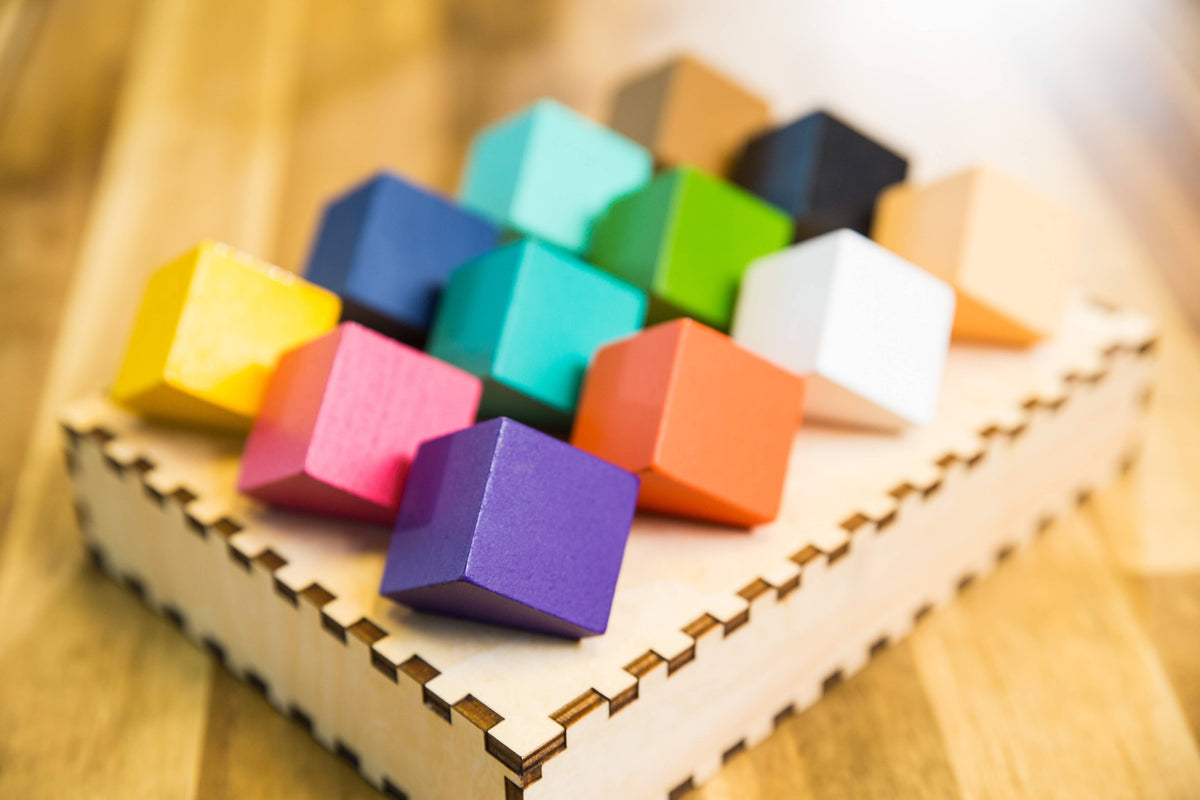 Close-up of multicolored cube pieces on a wooden tray base